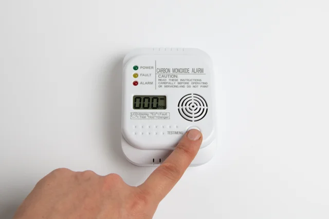Carbon monoxide alarm being tested for tenant safety in a rental home.