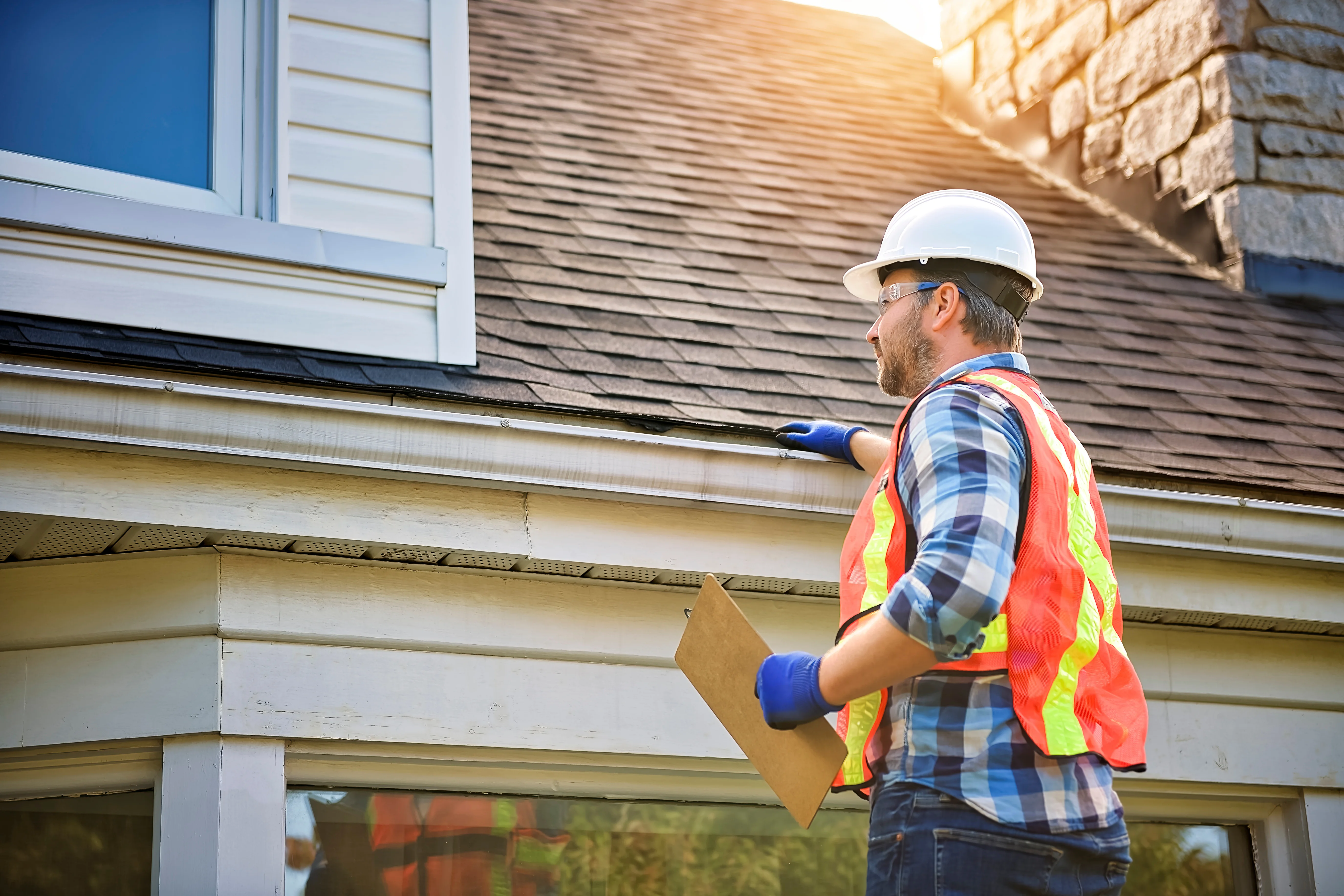 Property inspector checking roof for damage during seasonal rental maintenance.